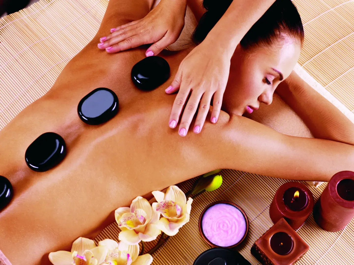A hot stone massage with candles and flowers at Oasis Palm.