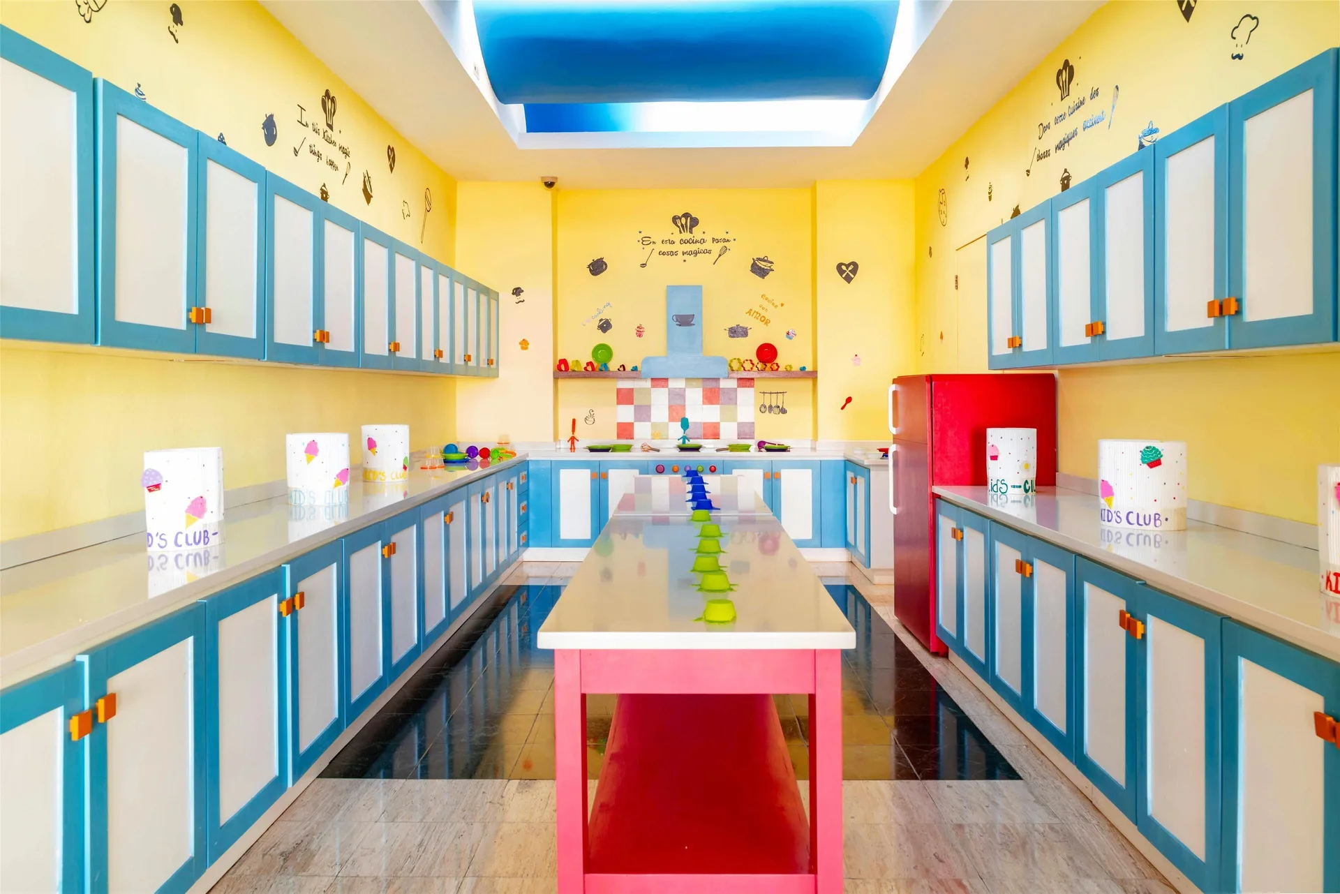Bright kids club craft room with blue cabinets and a central table at Oasis Palm.