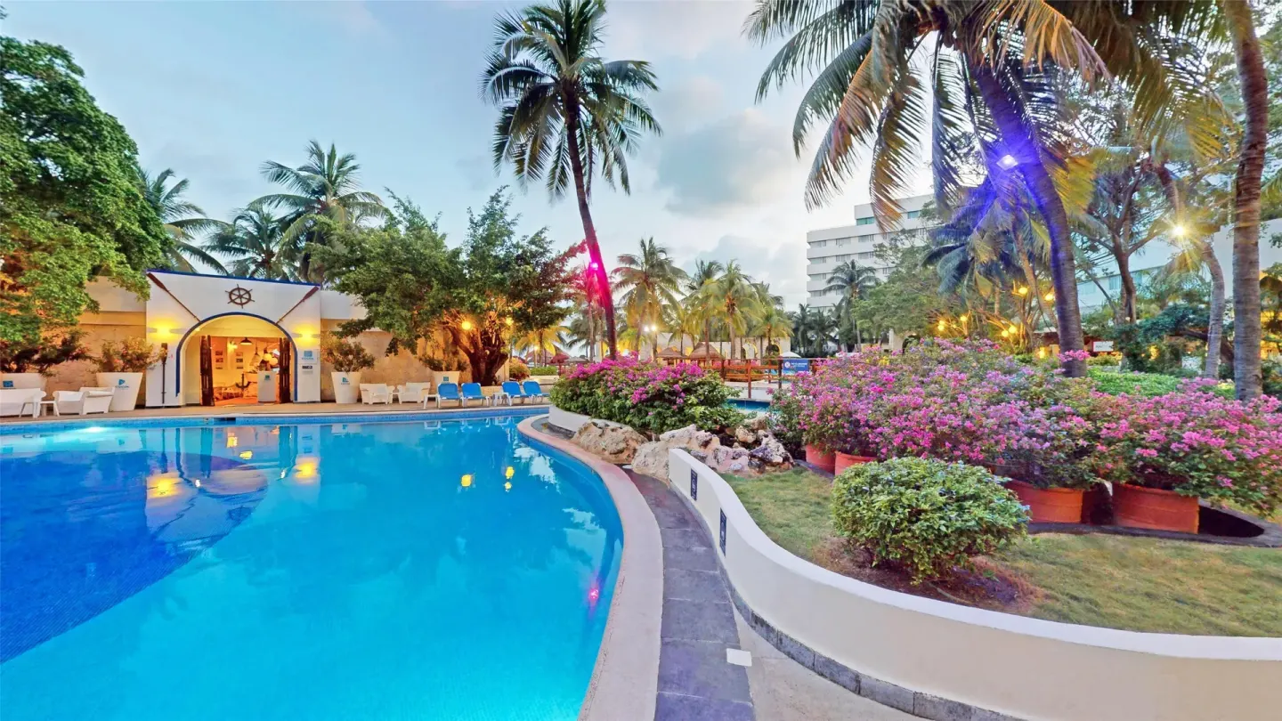 Lagoon-style pool with palms and flowering gardens at Oasis Palm.