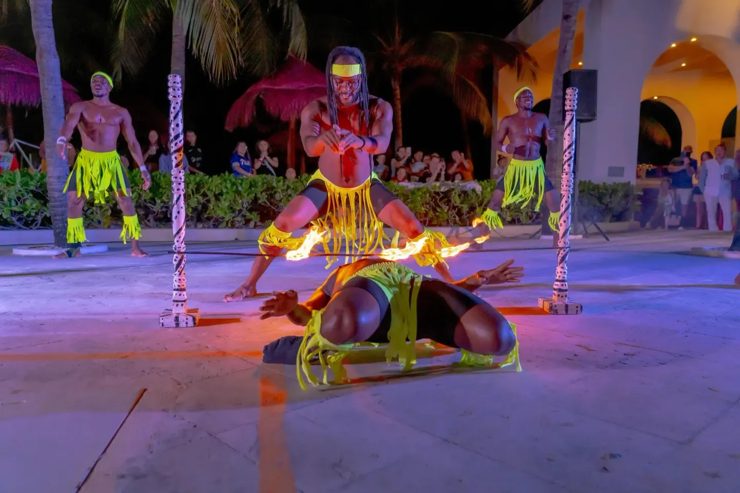 A nighttime fire performance with costumed dancers at Oasis Palm.
