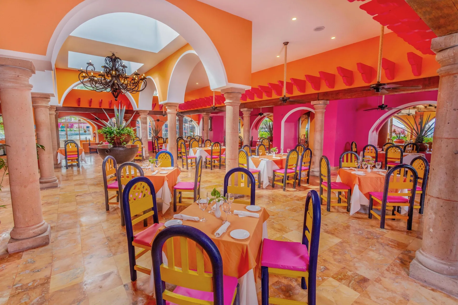 Colorful arched dining room with set tables at Oasis Palm.
