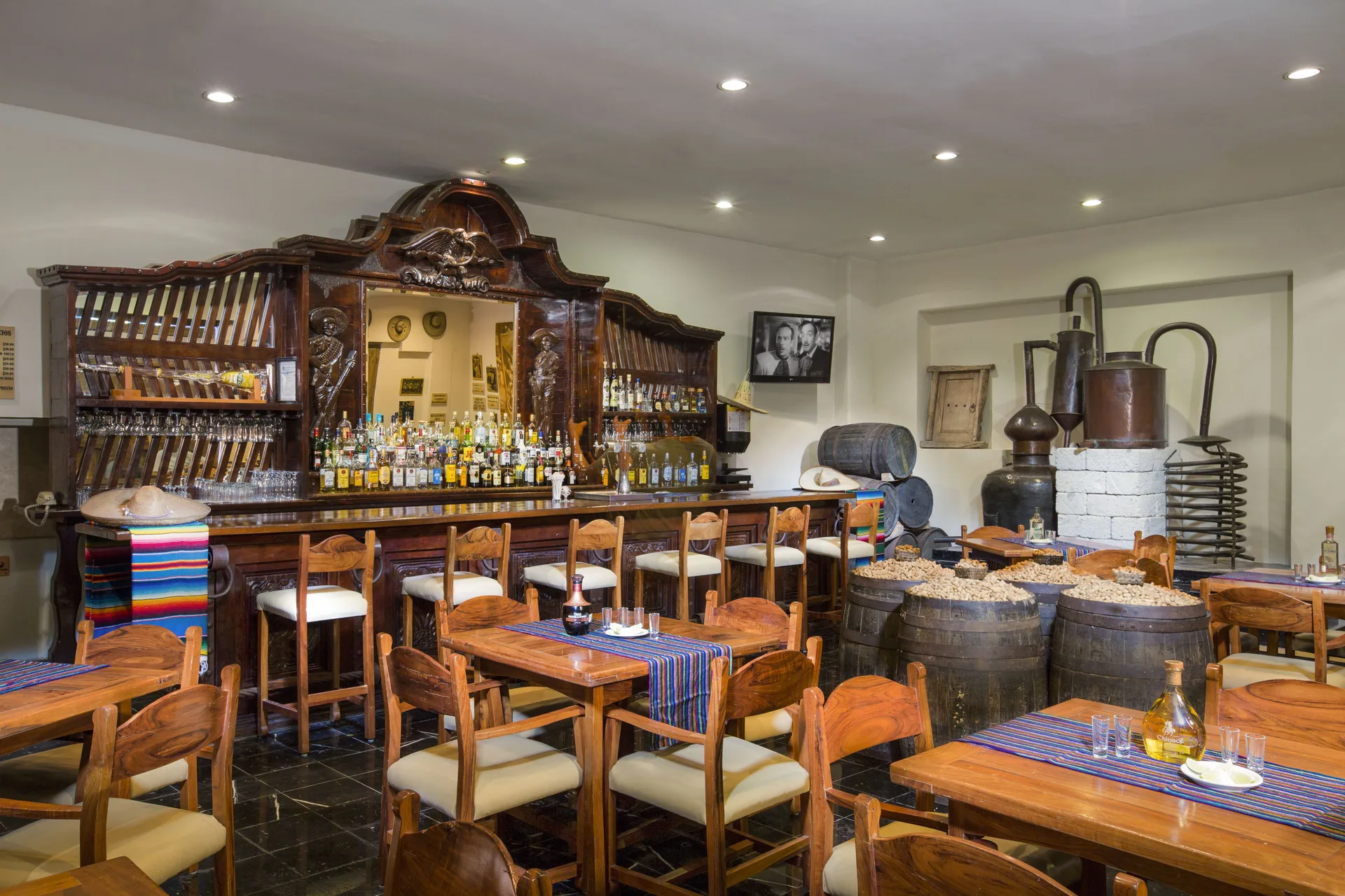 Rustic bar and dining room with wooden tables and barrels at Oasis Palm.