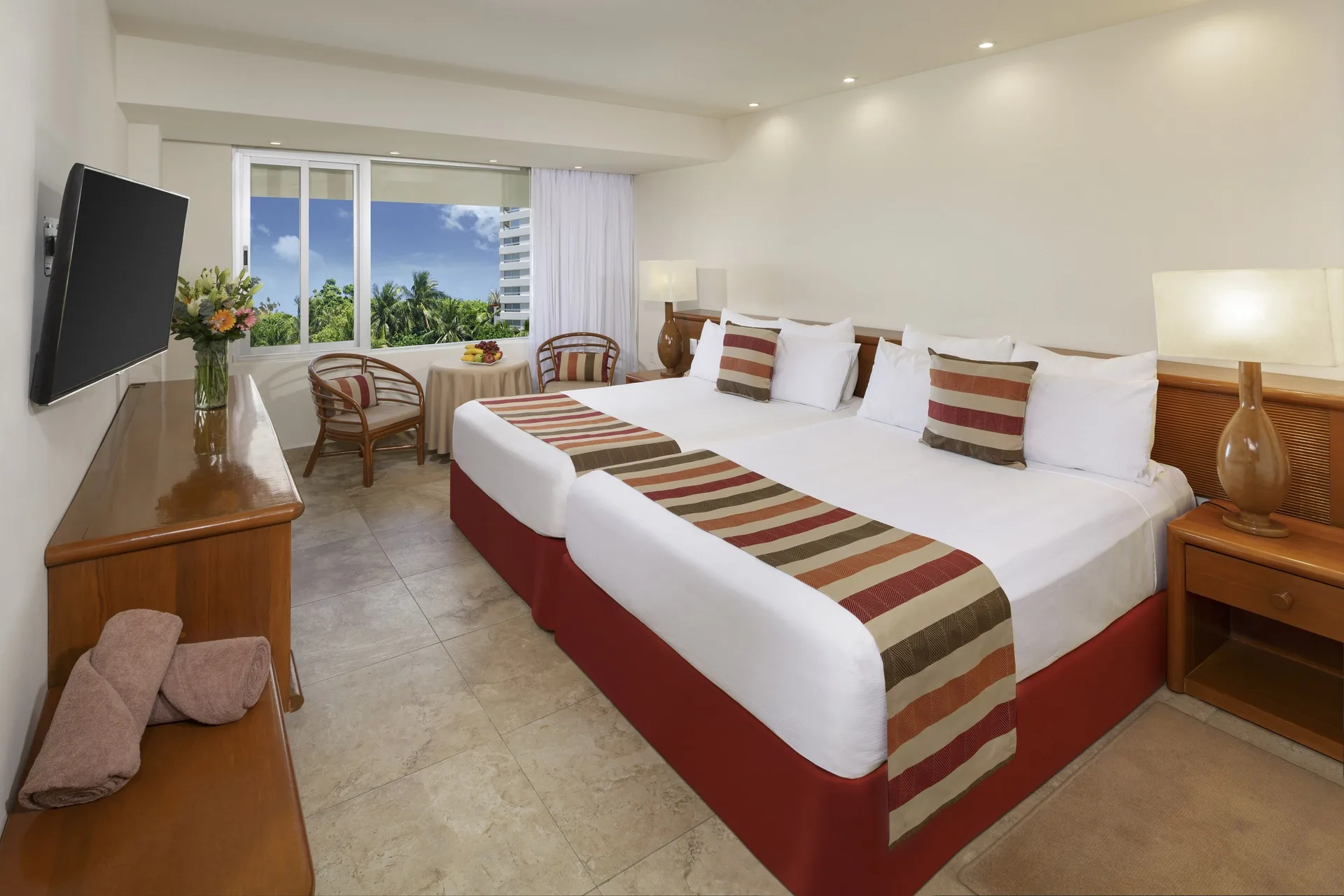 Standard guest room with two beds, window seating, and wall TV at Oasis Palm.