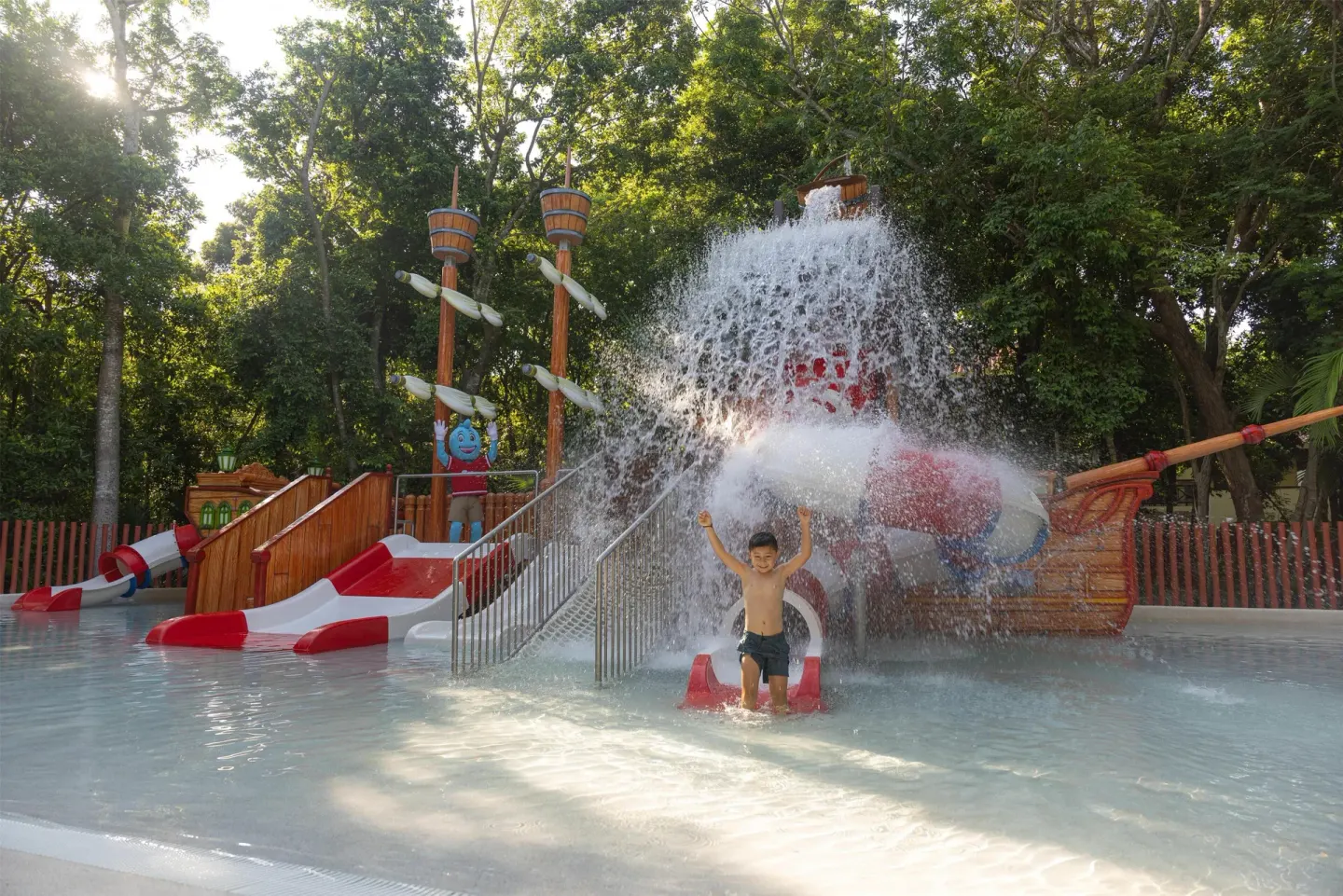 A child plays under cascading water in the kids' pool at Occidental at Xcaret Destination.