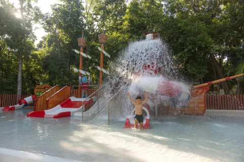 A child plays under cascading water in the kids' pool at Occidental at Xcaret Destination.