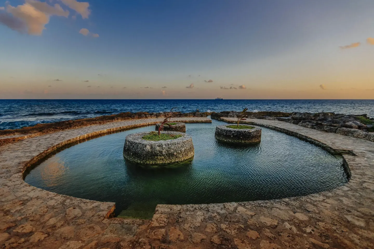 Oceanfront stone lagoon at sunset at Occidental at Xcaret Destination.