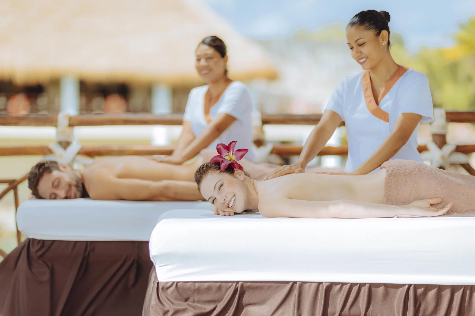 Two guests receive outdoor massages on spa tables at Occidental at Xcaret Destination.