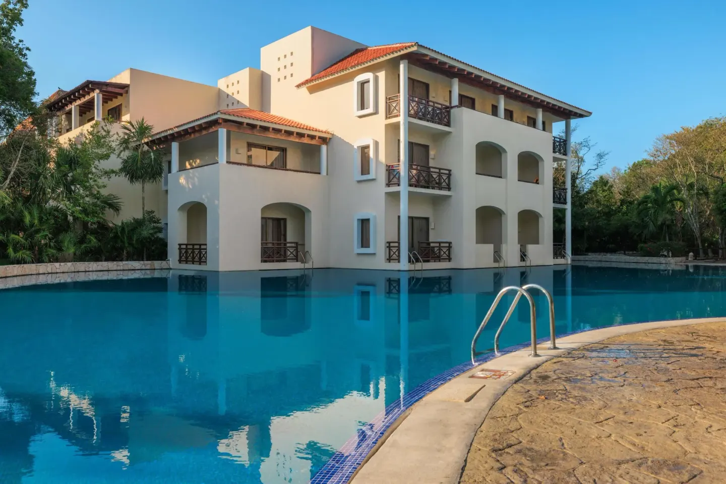 Poolside resort building with balconies at Occidental at Xcaret Destination.