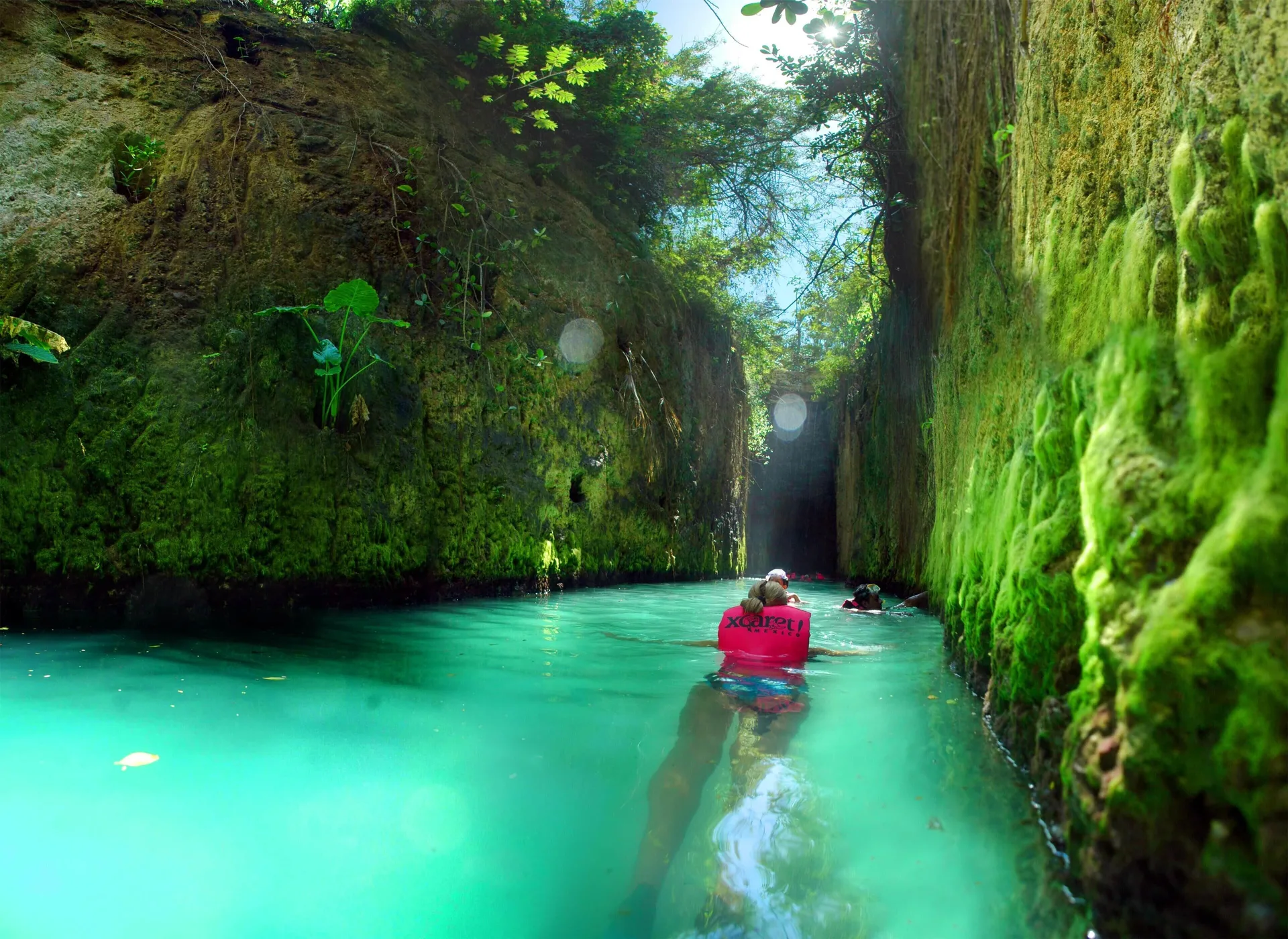 Swimmers float through a narrow turquoise channel at Occidental at Xcaret Destination.