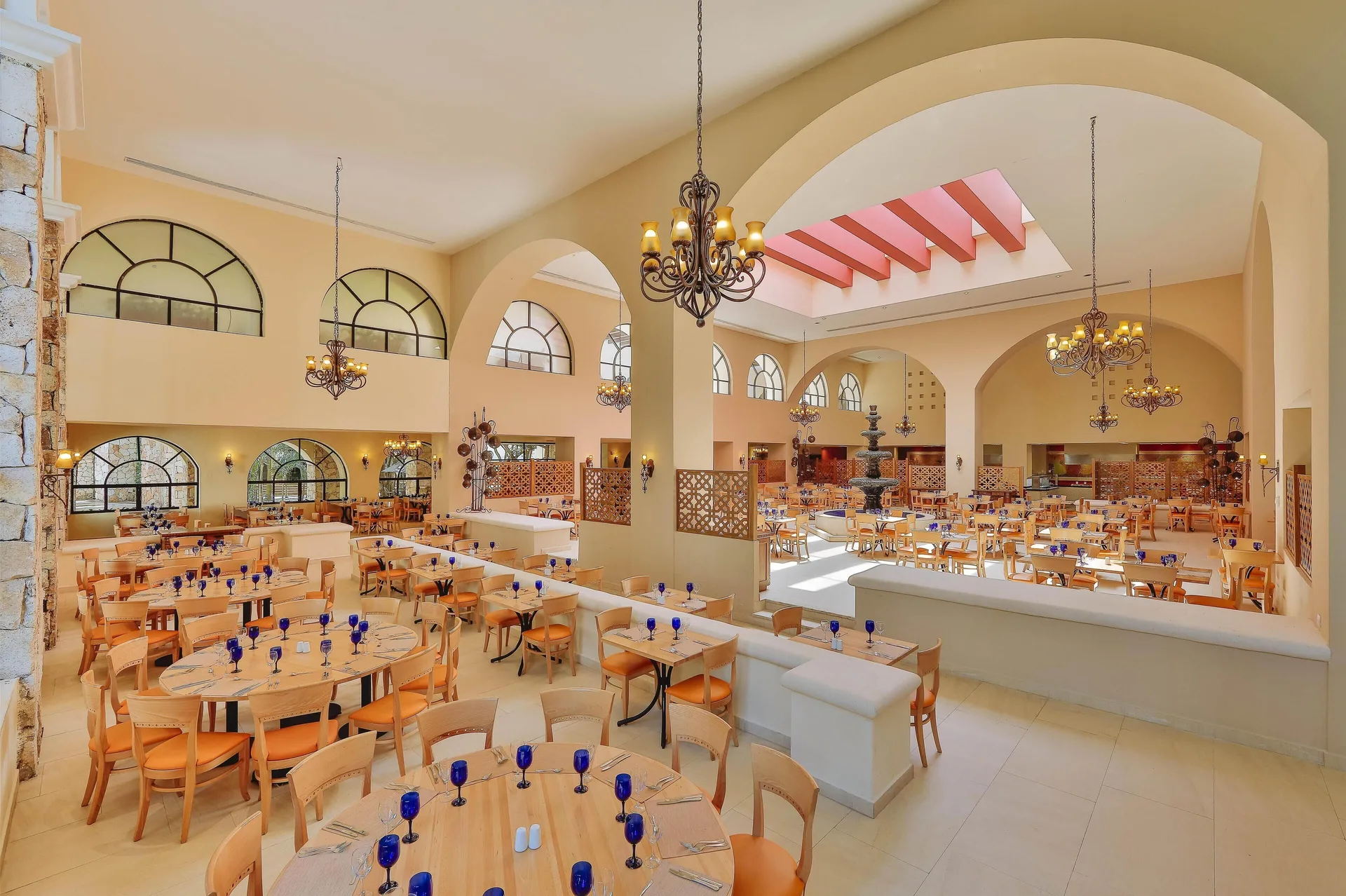 Large bright buffet dining room with blue goblets at Occidental at Xcaret Destination.