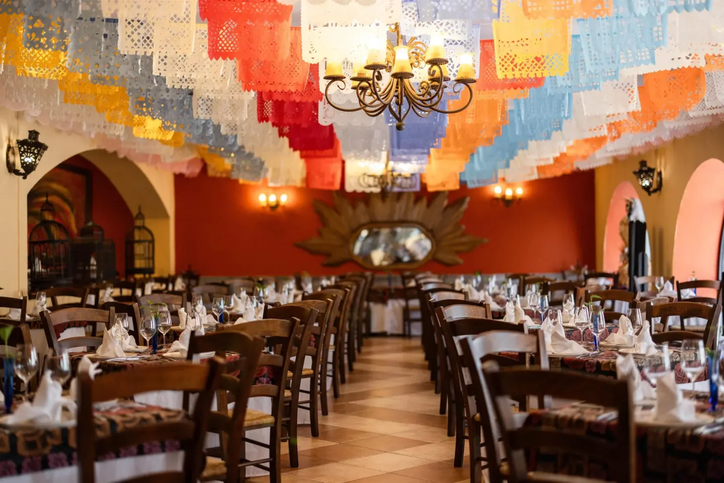 Colorful papel picado hangs over a set dining room at Occidental at Xcaret Destination.