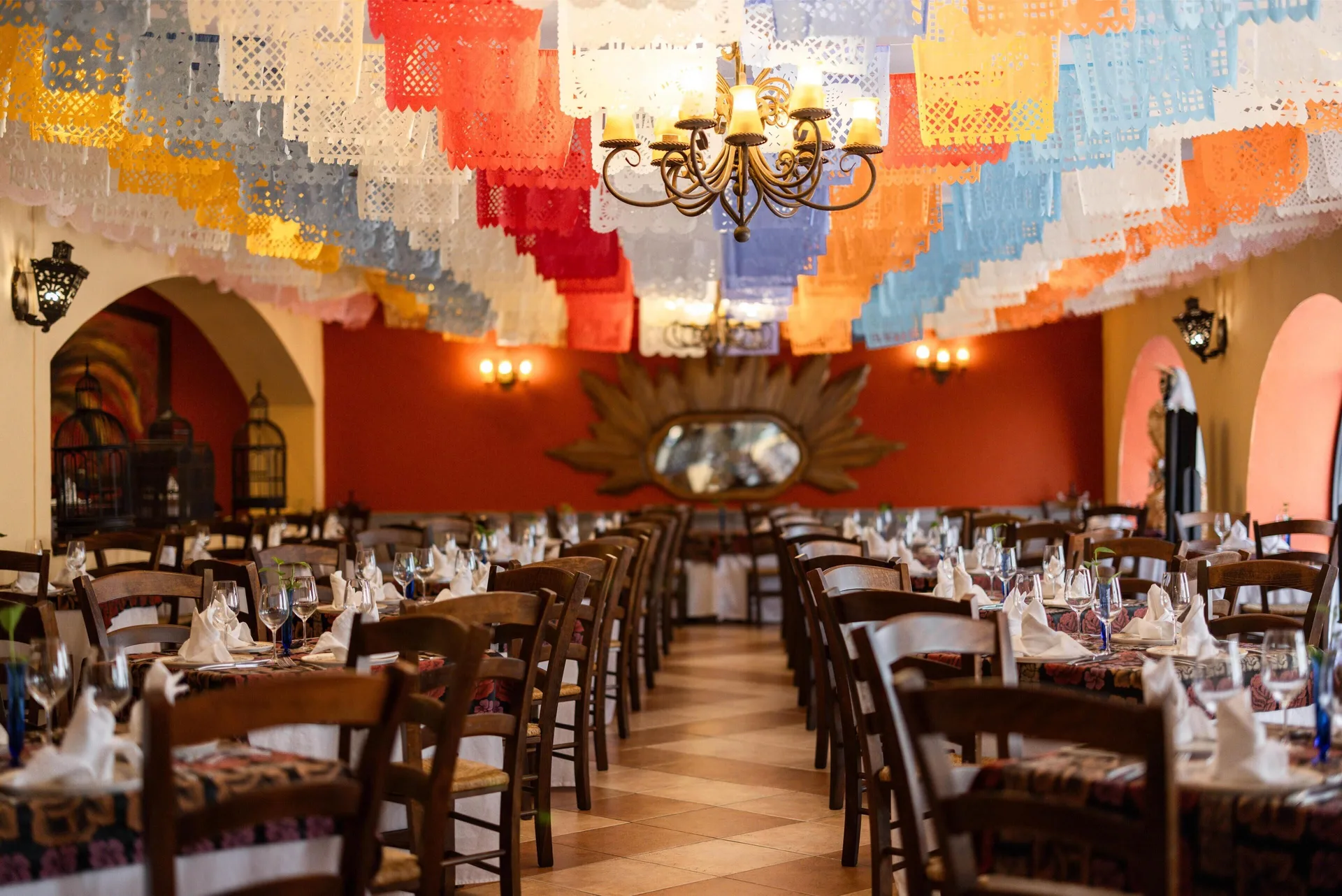 Colorful papel picado hangs over a set dining room at Occidental at Xcaret Destination.
