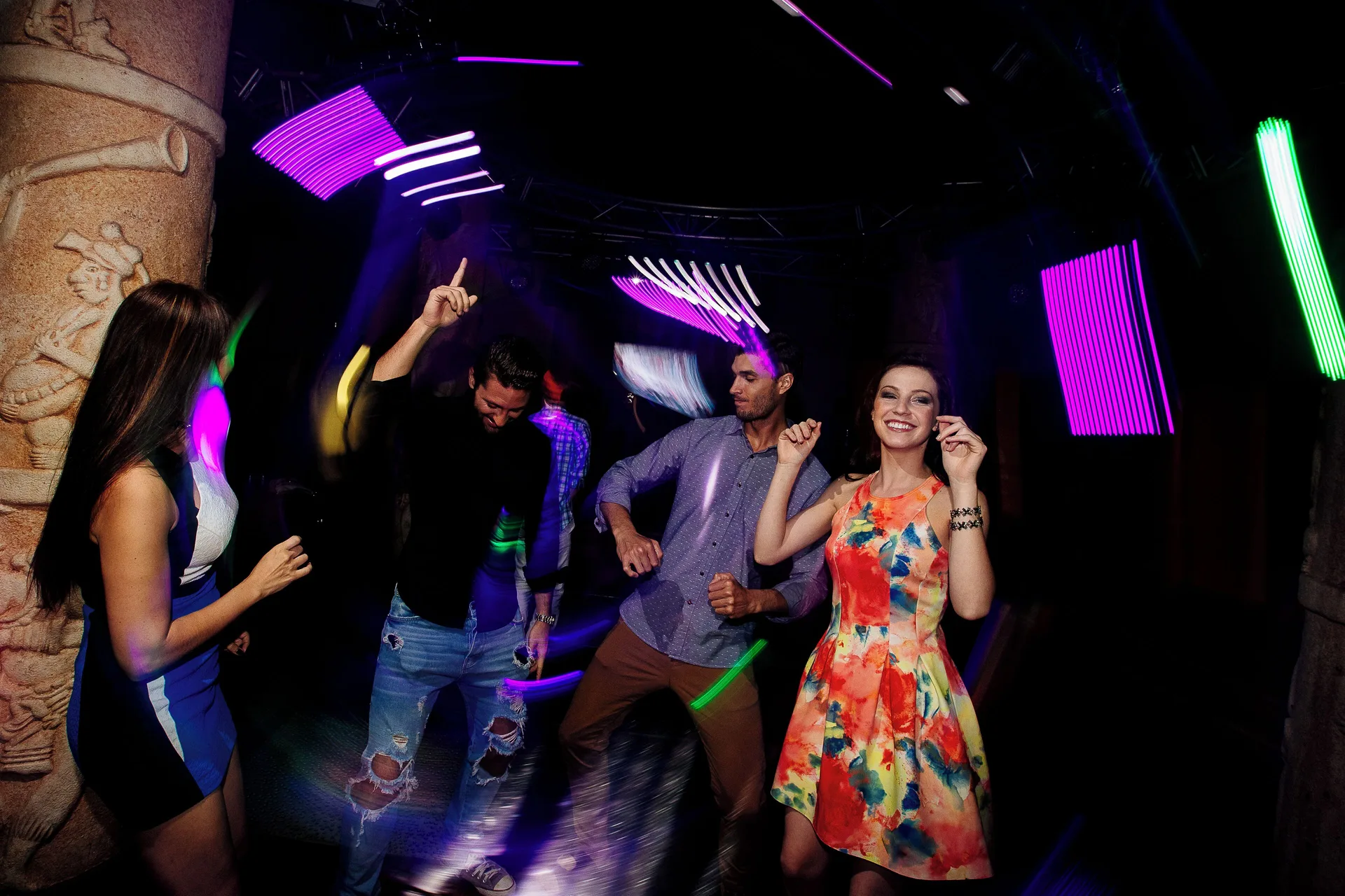 Guests dance under neon lights in a nightclub at Occidental at Xcaret Destination.