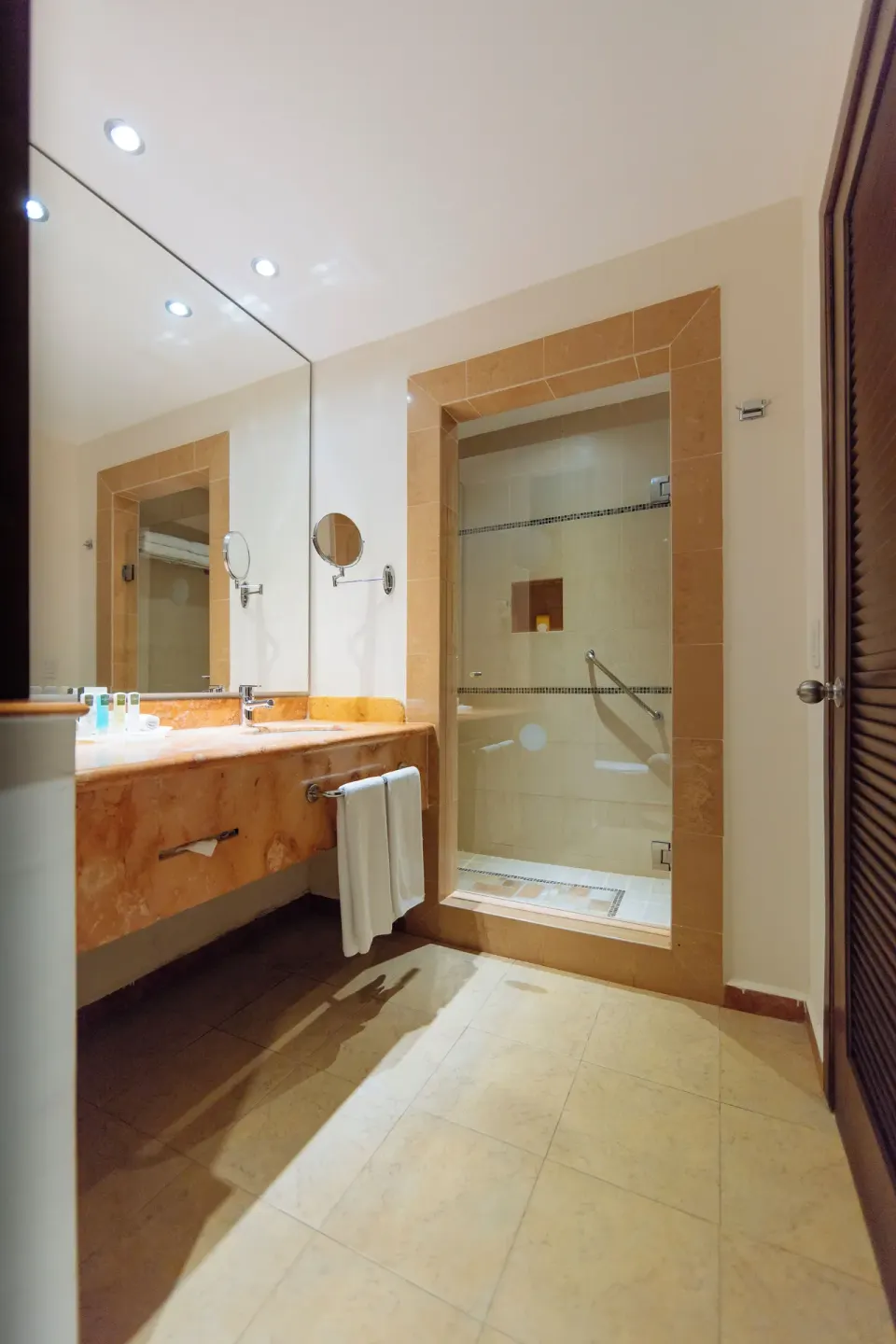 Deluxe Room bathroom with vanity and walk-in shower at Occidental at Xcaret Destination.