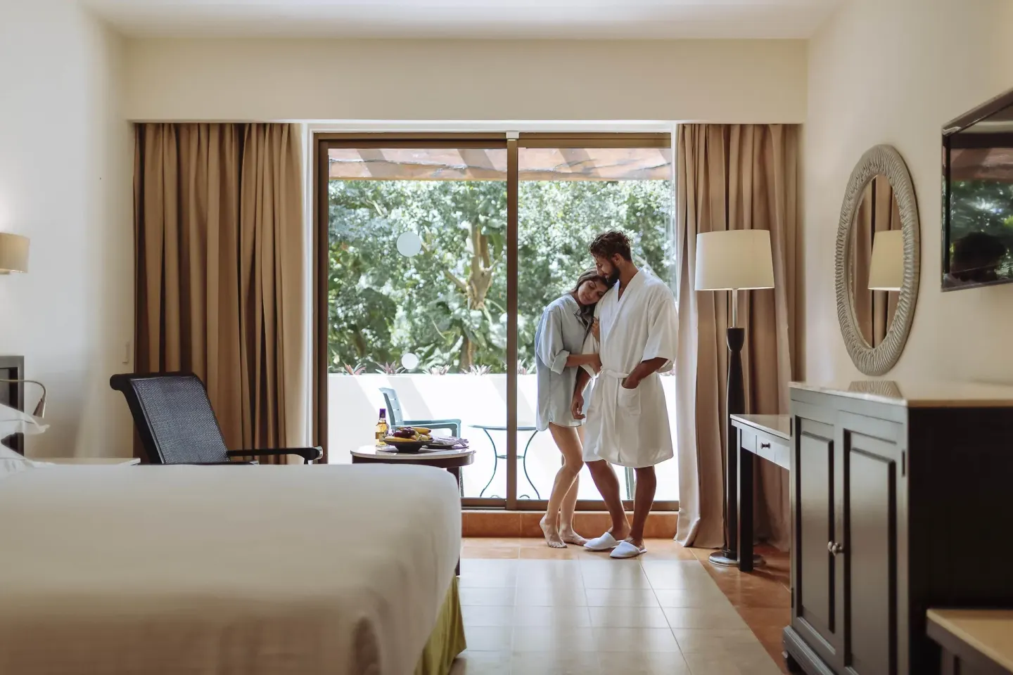 Deluxe Room with bed, seating and balcony doors at Occidental at Xcaret Destination.