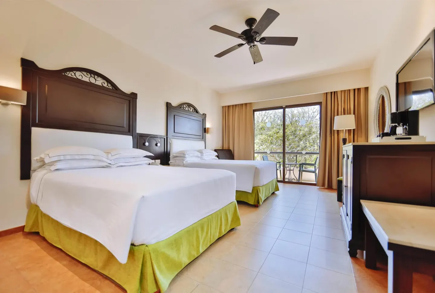 Deluxe Room with two beds and balcony doors at Occidental at Xcaret Destination.
