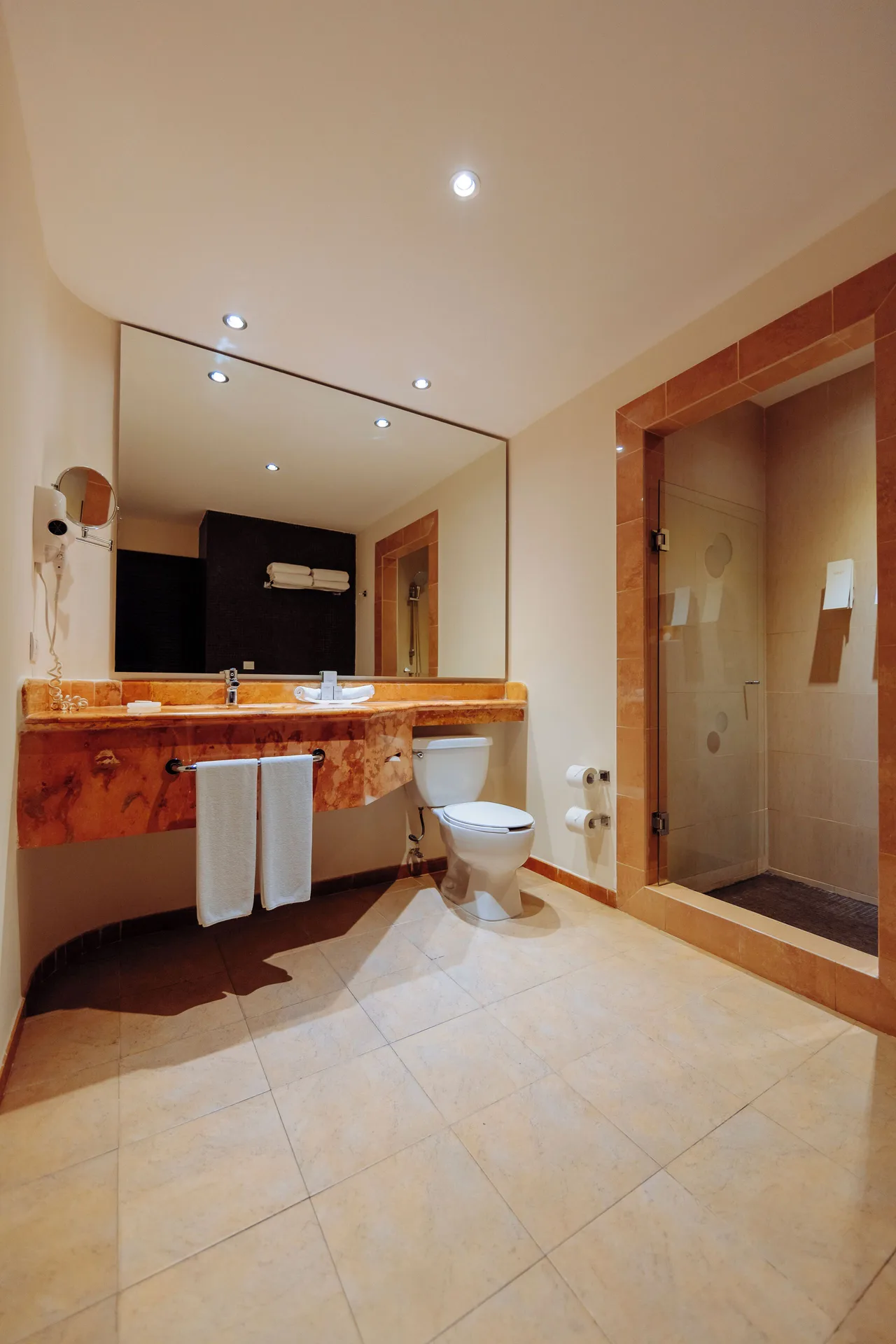 Junior Studio Suite bathroom with long vanity and glass shower at Occidental at Xcaret Destination.