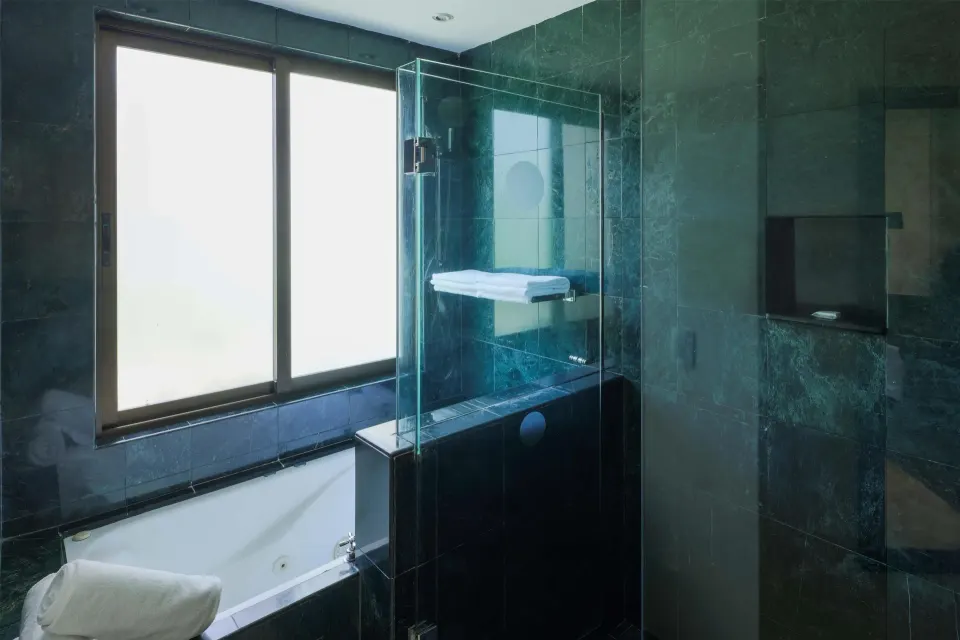 Luxury Room Royal Level bathroom with tub and glass shower at Occidental at Xcaret Destination.