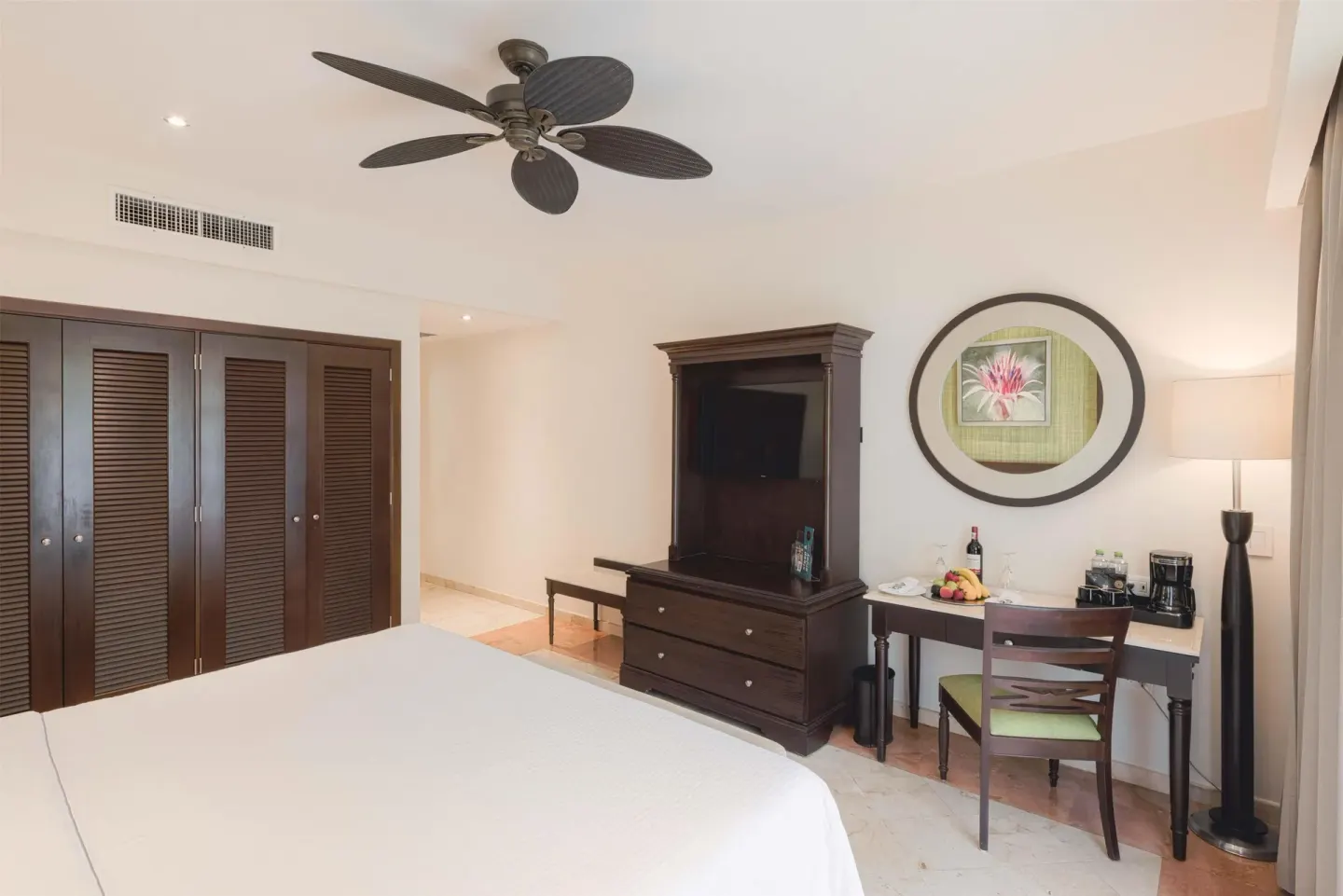 Luxury Room king bed with TV cabinet, desk, and coffee setup at Occidental at Xcaret Destination.
