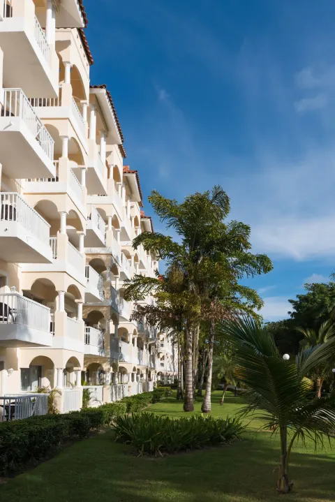 White balcony building and landscaped lawn at Occidental Caribe.