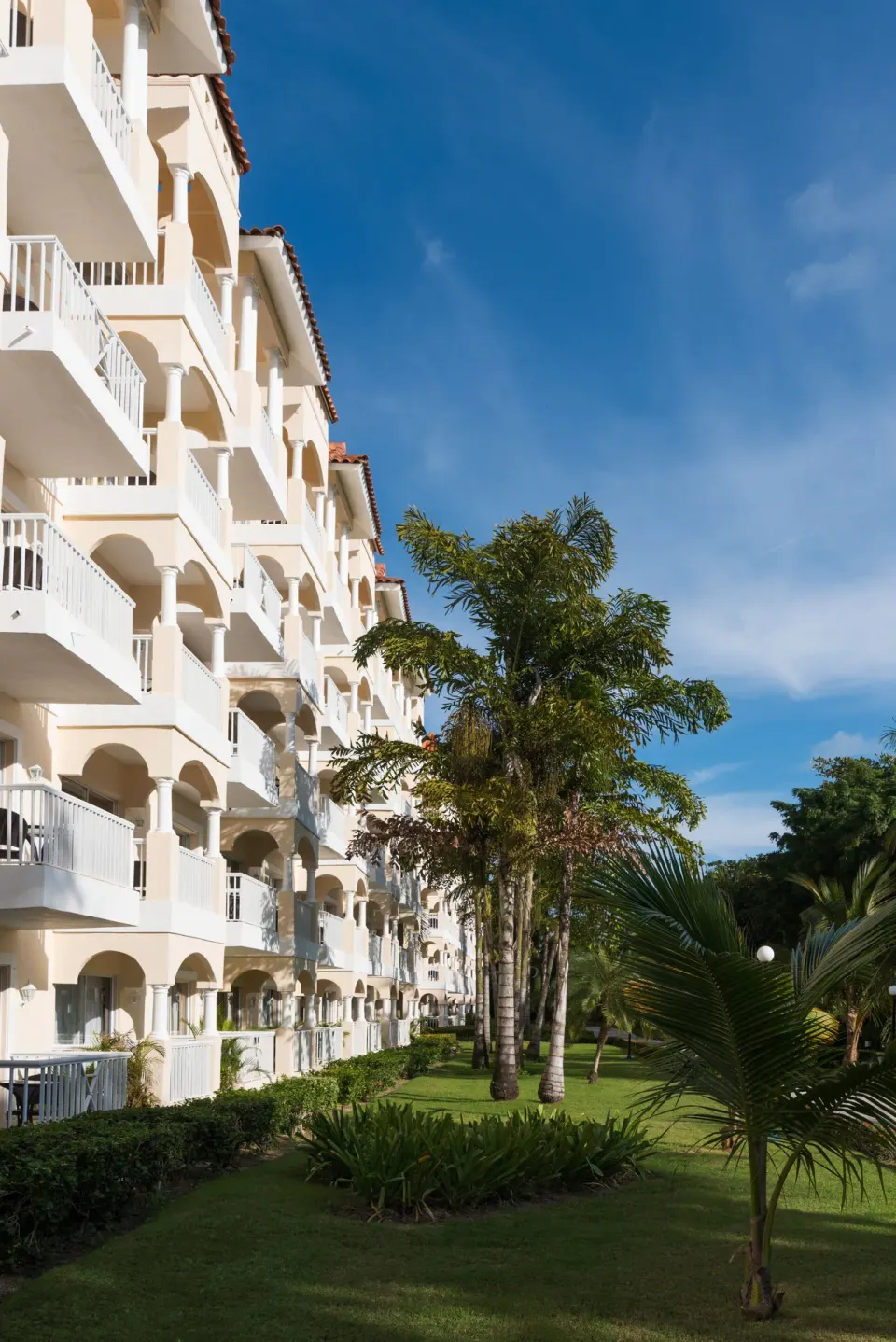 White balcony building and landscaped lawn at Occidental Caribe.