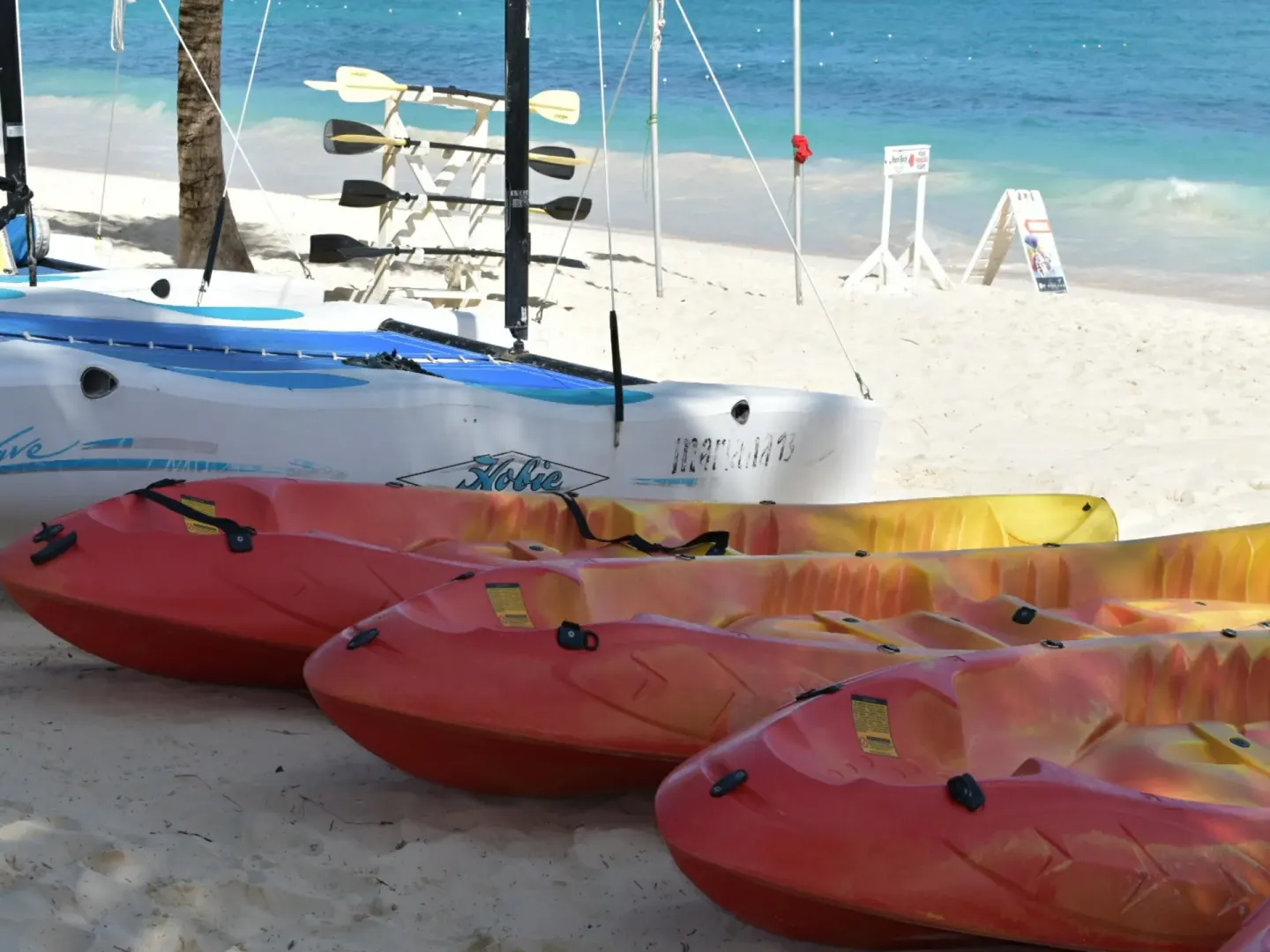 Kayaks and a small sailboat rest on the beach at Occidental Caribe.