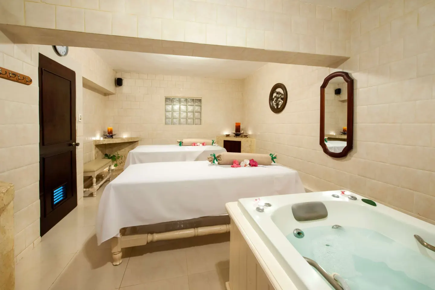 Massage room with two treatment beds and a whirlpool tub at Occidental Caribe.