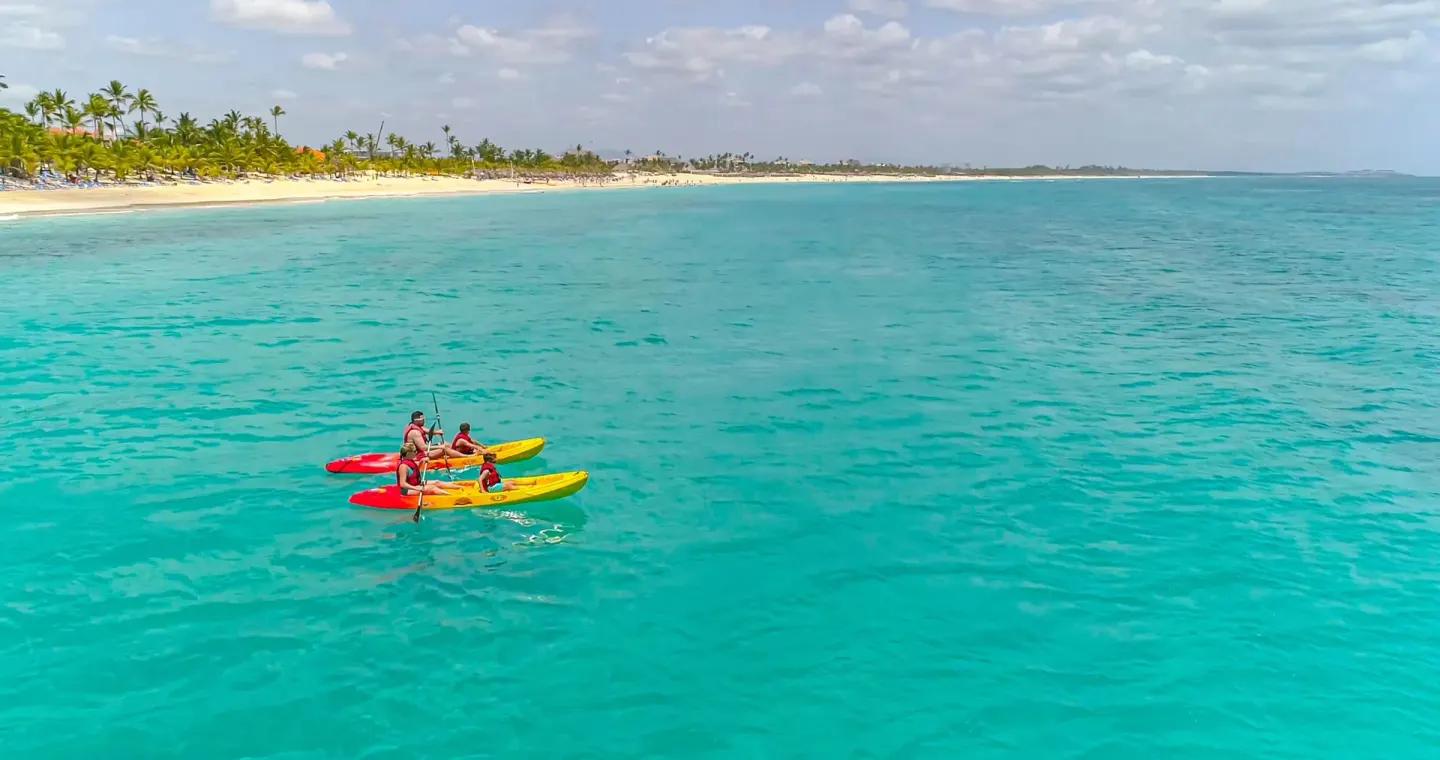 Guests paddle kayaks on clear turquoise water near Occidental Caribe.