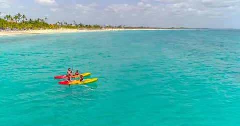 Guests paddle kayaks on clear turquoise water near Occidental Caribe.