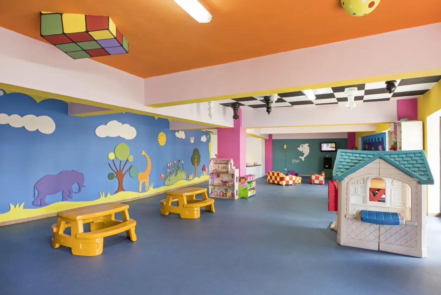 Colorful kids club playroom with murals and toy houses at Occidental Caribe.