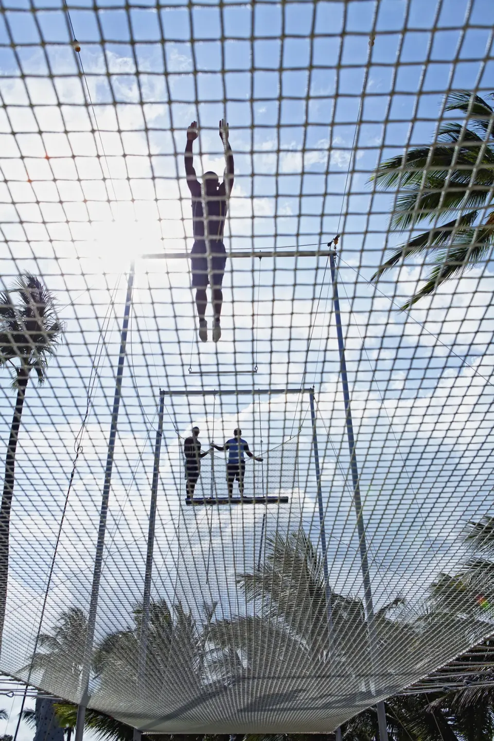 Guest climbing on a netted trapeze-style activity at Occidental Caribe.