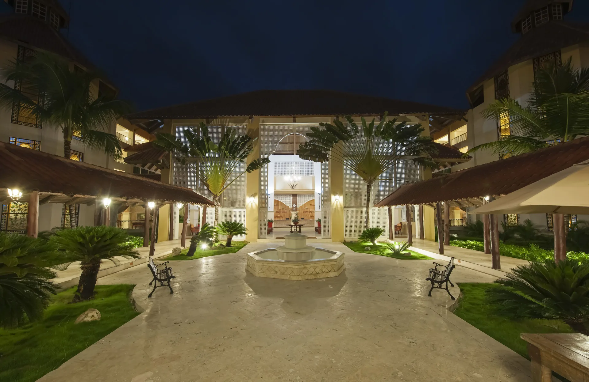 Illuminated courtyard with fountain at night at Occidental Caribe.