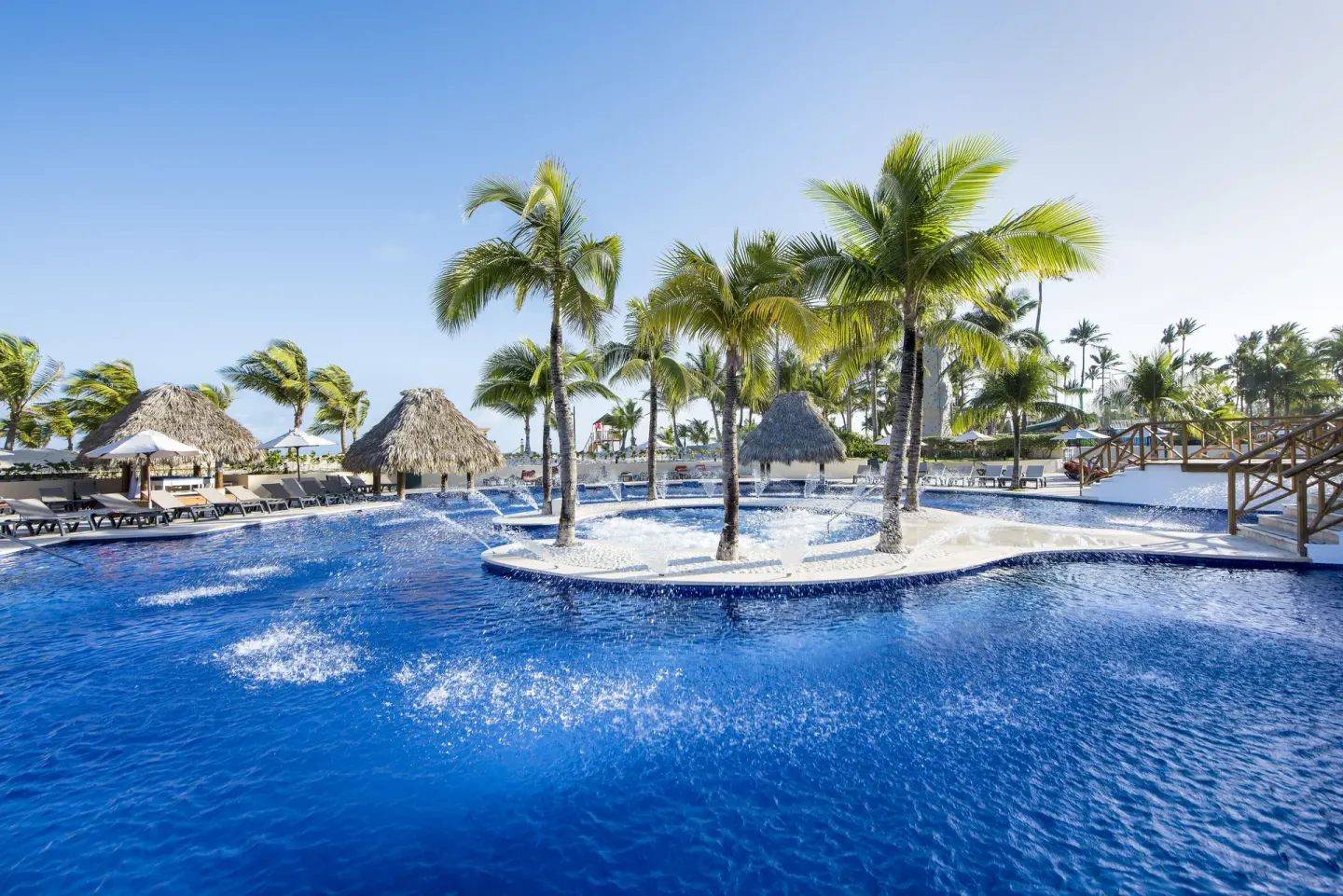 Palm island and bright blue swimming pool at Occidental Caribe.