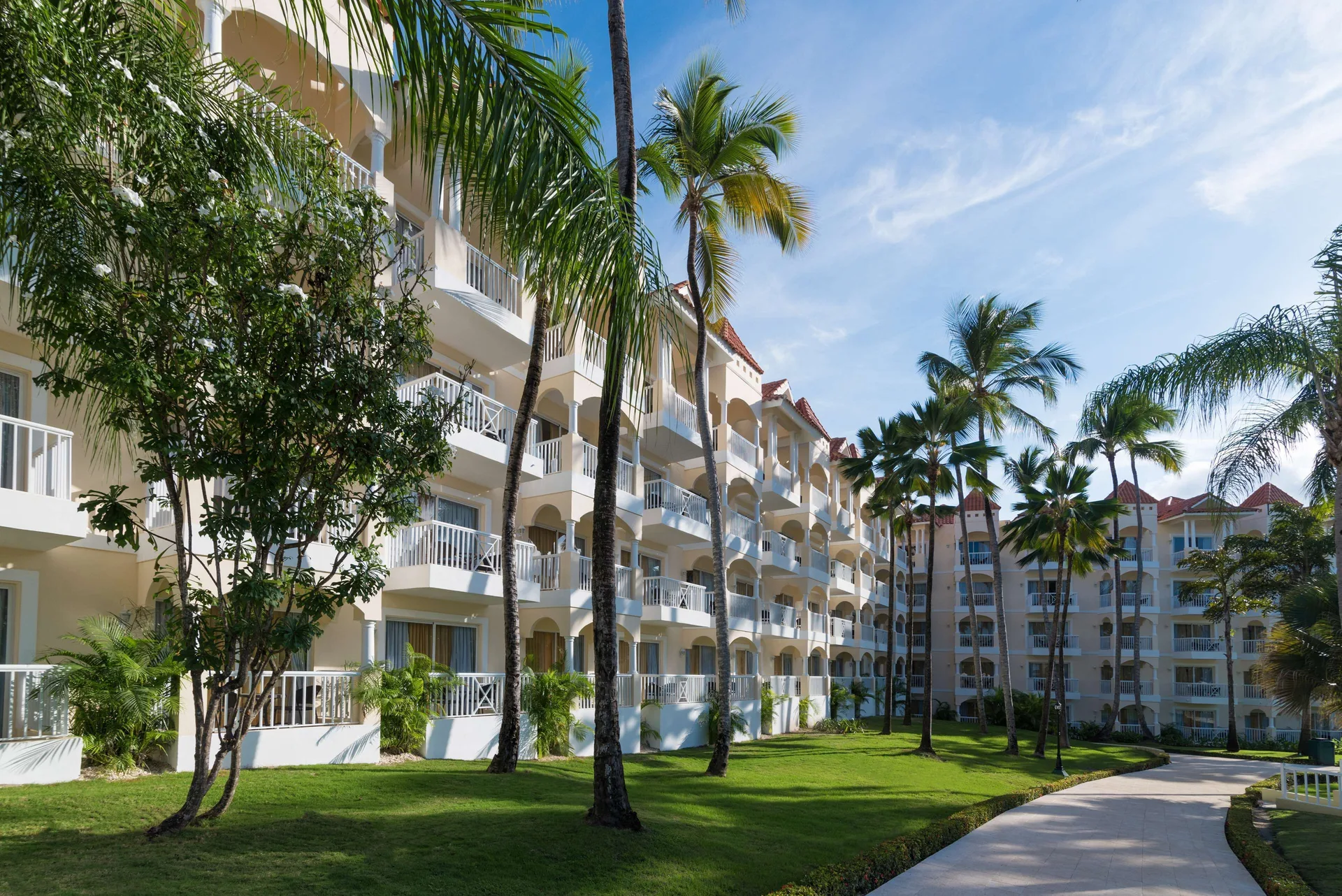 Palm-lined walkway beside guestroom buildings at Occidental Caribe.