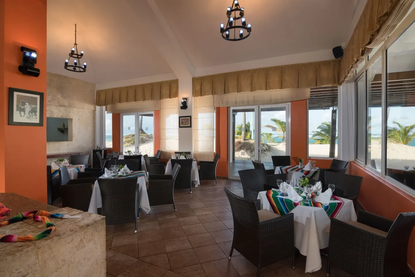 Seaside dining room with set tables and ocean views at Occidental Caribe.