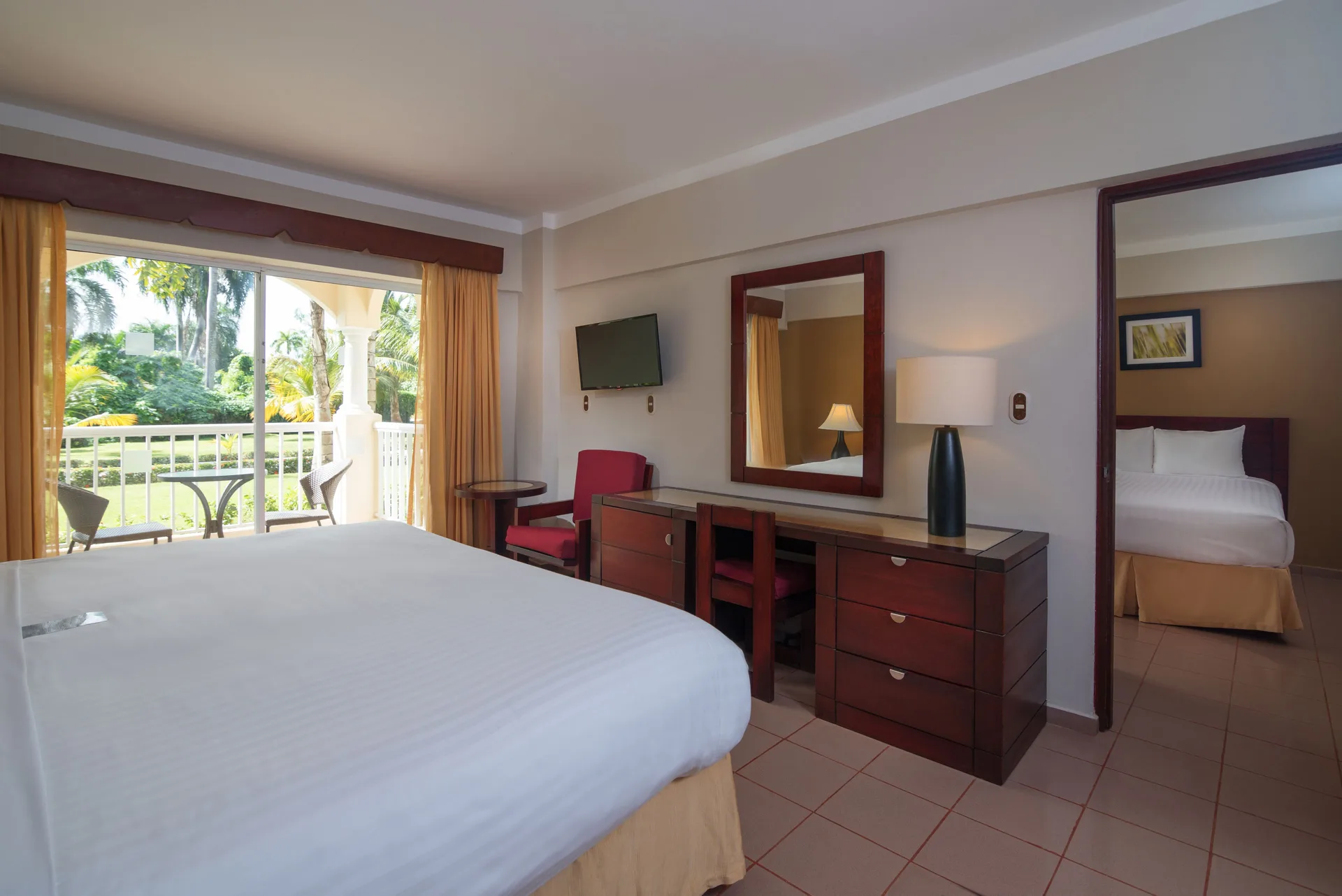 Family Room with king bed, dresser, balcony, and second bedroom at Occidental Caribe.