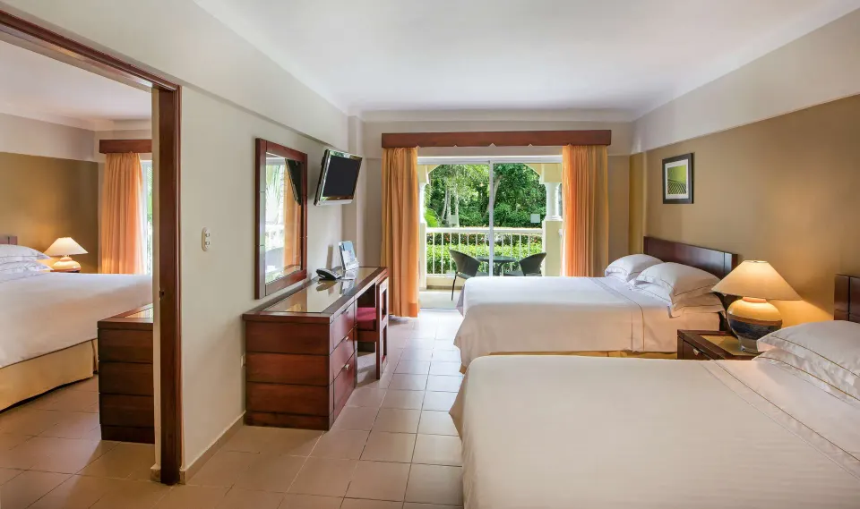 Family Room with two beds, balcony, desk, and adjoining bedroom at Occidental Caribe.