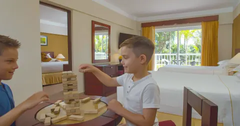 Family Room with two children playing blocks beside the beds at Occidental Caribe.