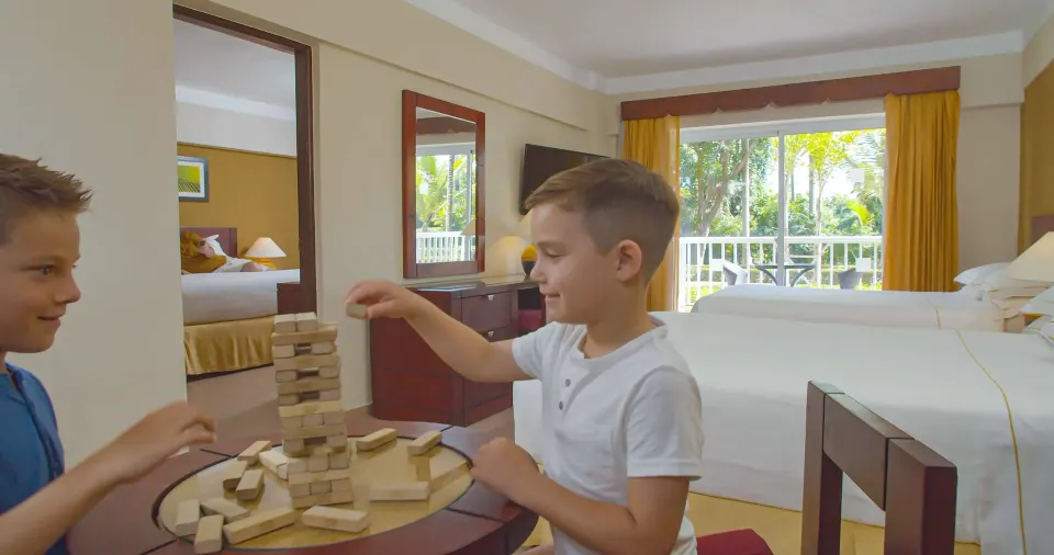 Family Room with two children playing blocks beside the beds at Occidental Caribe.