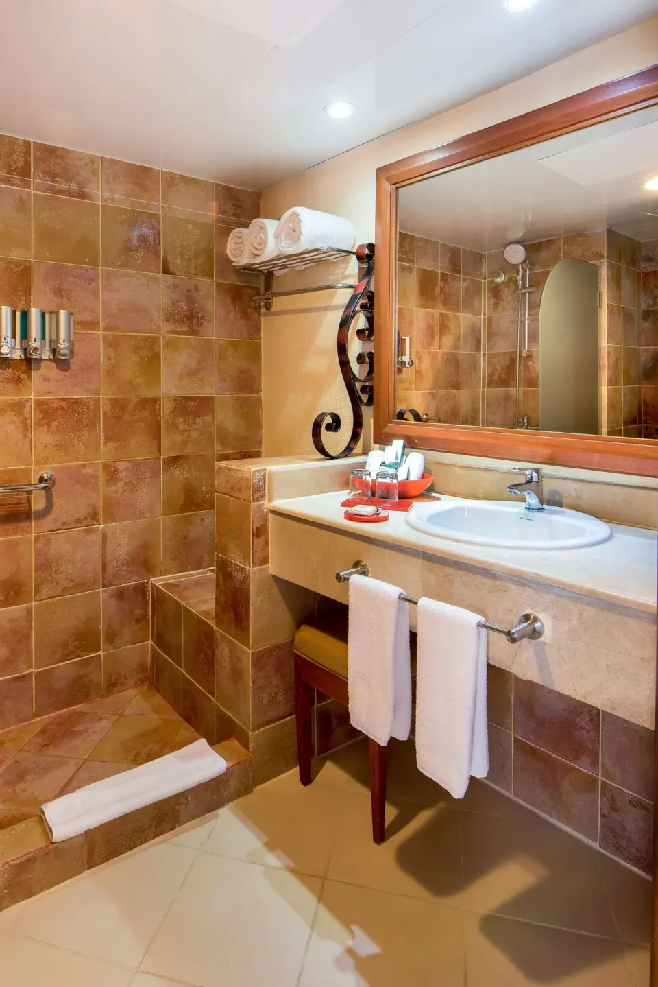 Tiled bathroom with vanity, towels, and walk-in shower in an Ocean View room at Occidental Caribe.