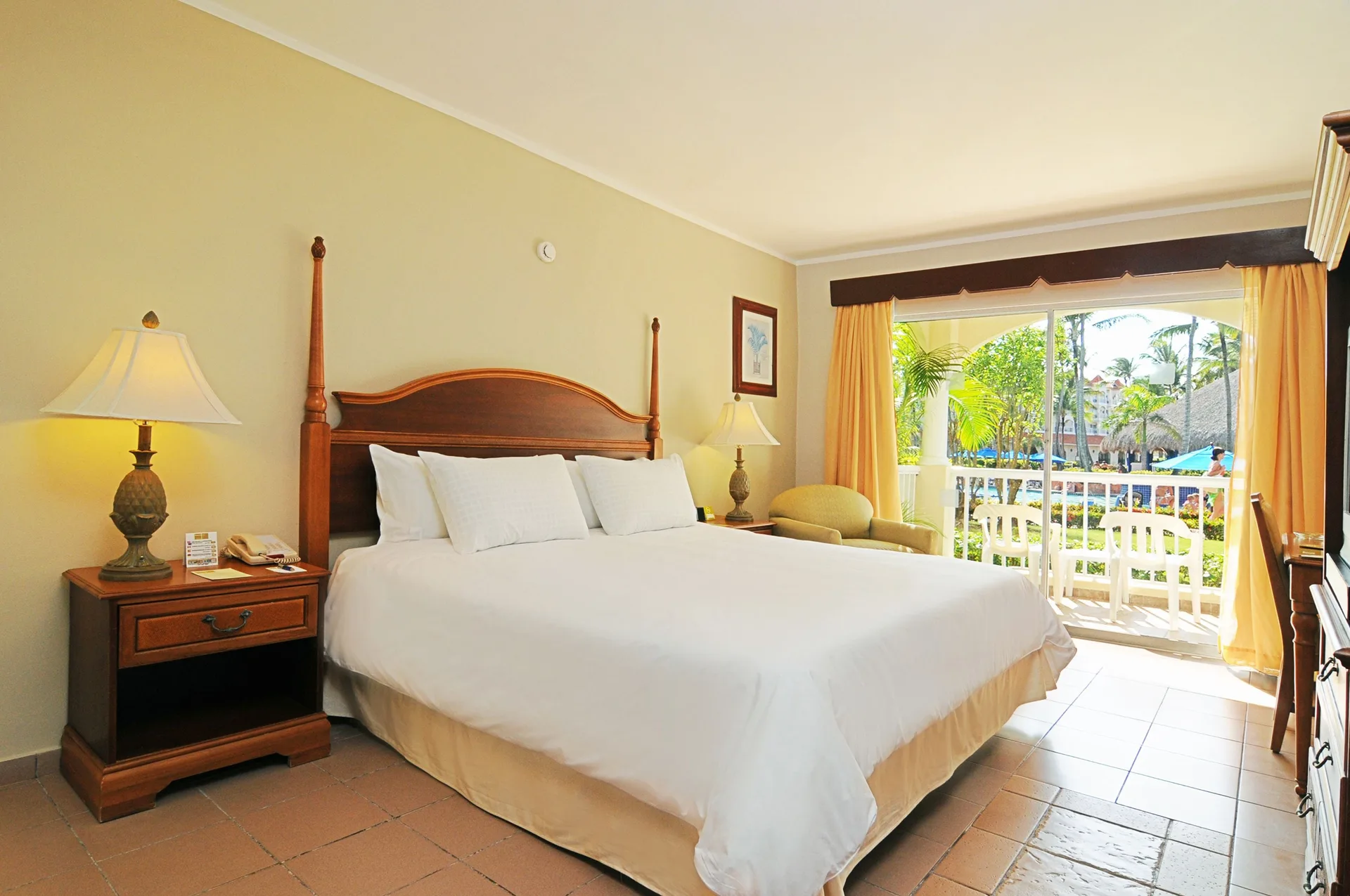 King guest room with balcony and poolside view at Occidental Caribe.