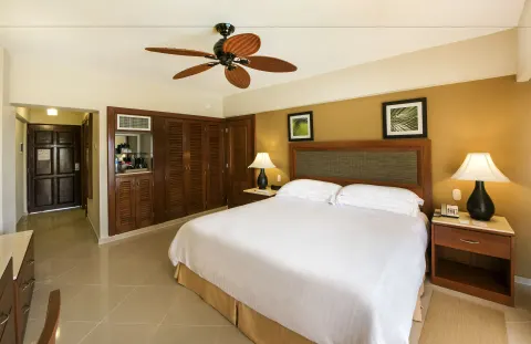 Superior Room king bed with closet and entry area at Occidental Caribe.