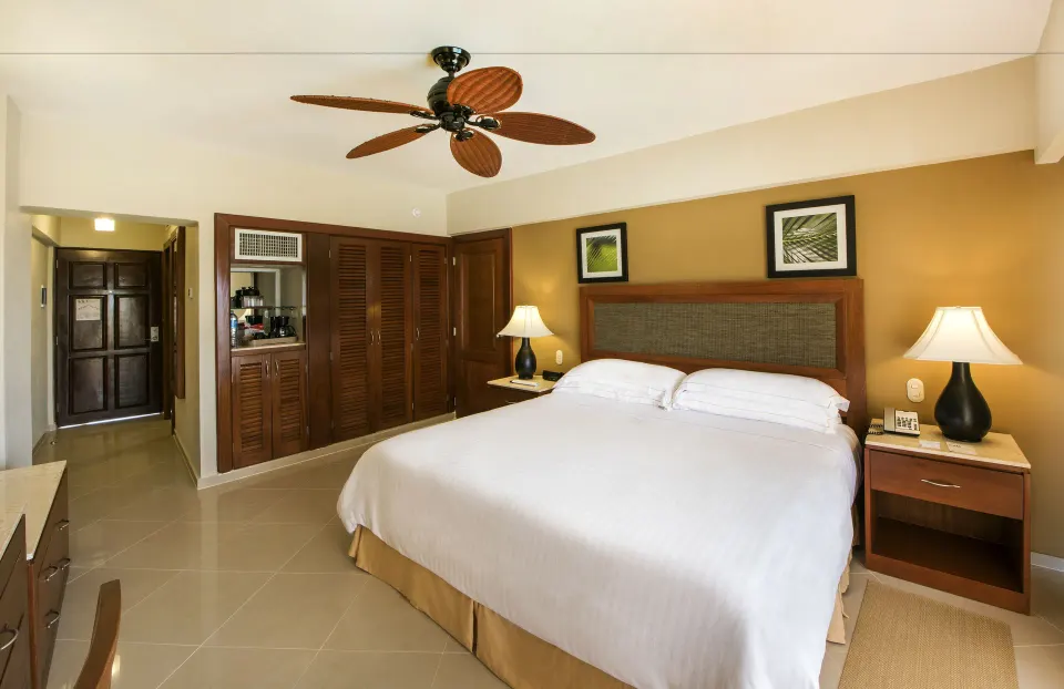 Superior Room king bed with closet and entry area at Occidental Caribe.