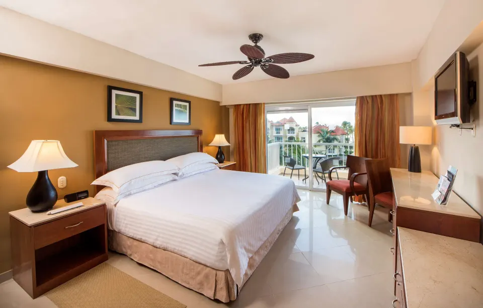 Superior Room with king bed, desk, TV, and balcony at Occidental Caribe.