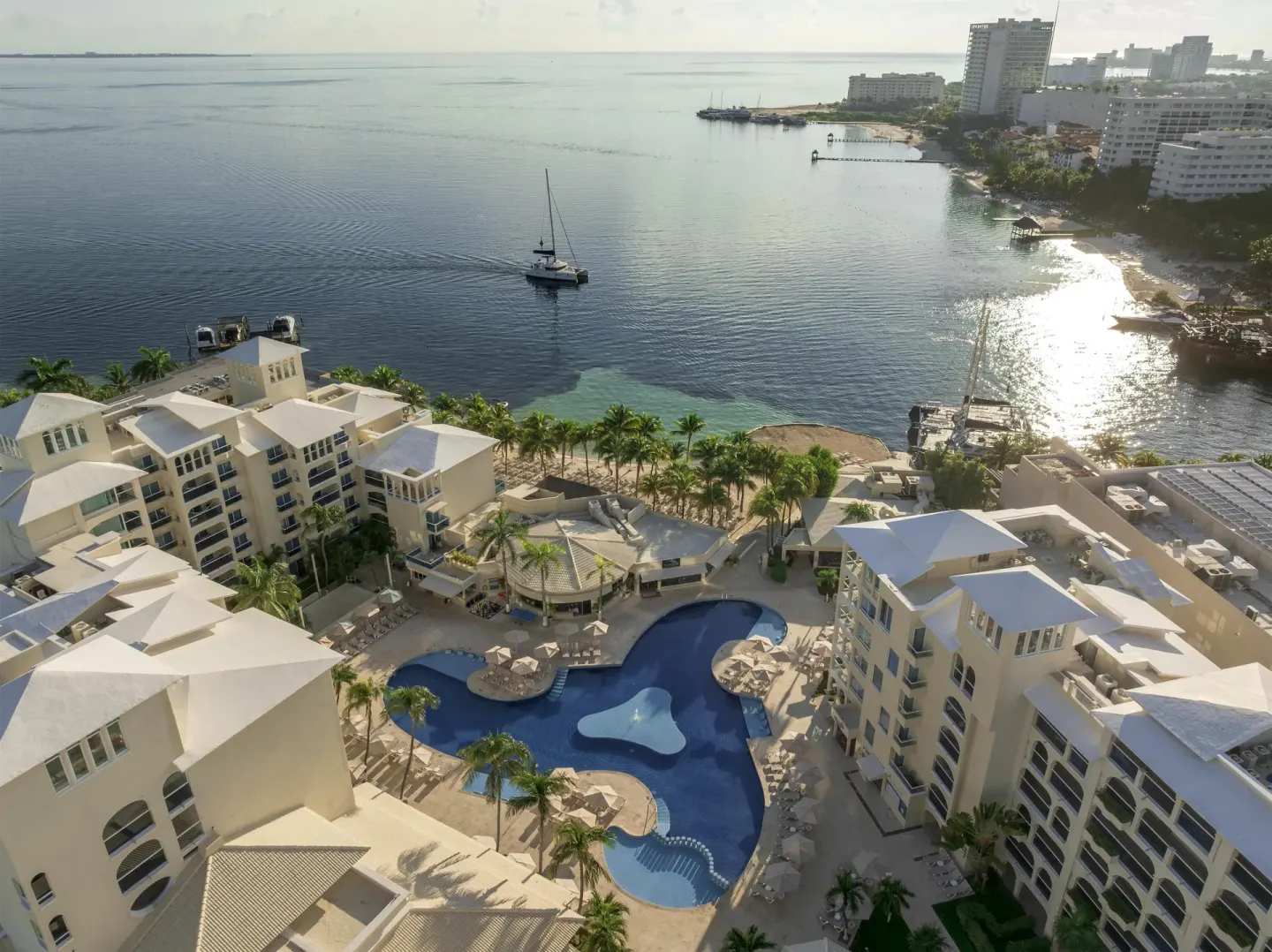 Aerial view of the pool, beachfront buildings, and bay at Occidental Costa Cancún.