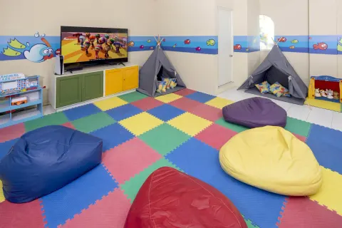 Indoor kids' room with beanbags, teepees and a TV at Occidental Costa Cancún.