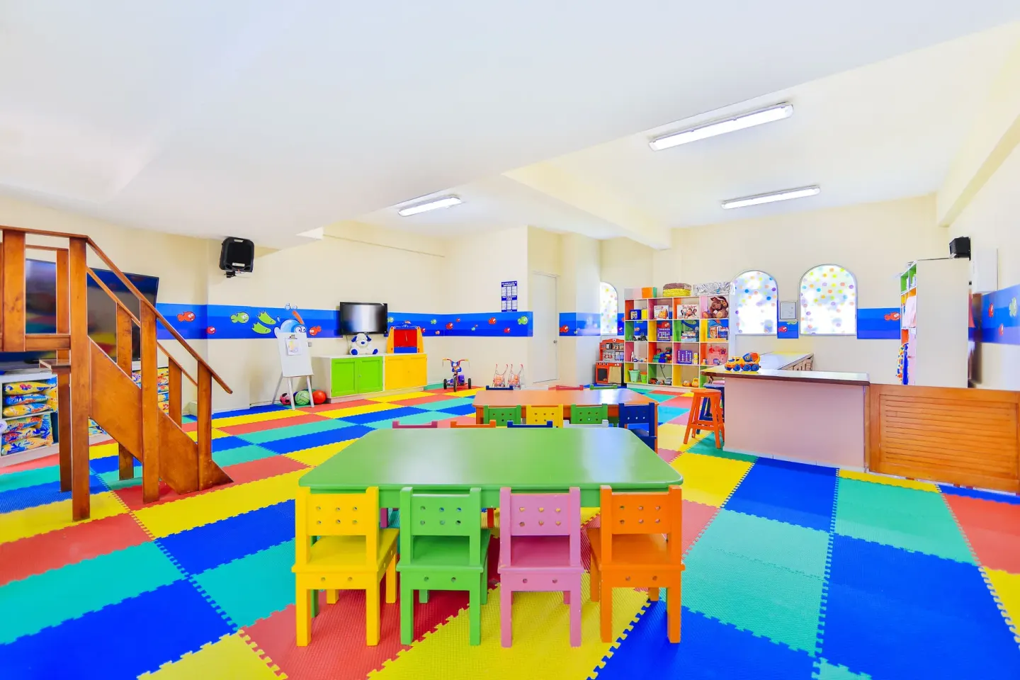 Colorful kids' activity room with small tables and chairs at Occidental Costa Cancún.