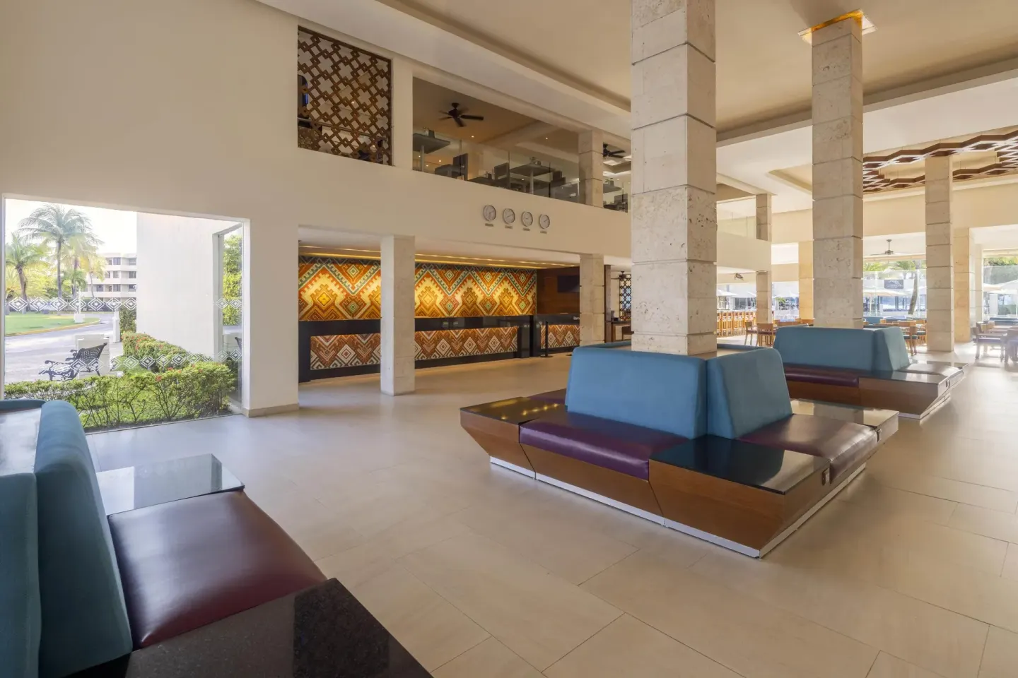 Lobby reception area with patterned front desk and lounge seating at Occidental Costa Cancún.