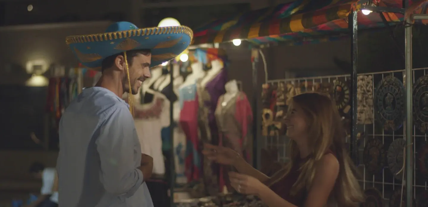 Night market stall with a guest trying on a sombrero at Occidental Costa Cancún.