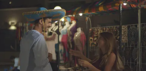 Night market stall with a guest trying on a sombrero at Occidental Costa Cancún.